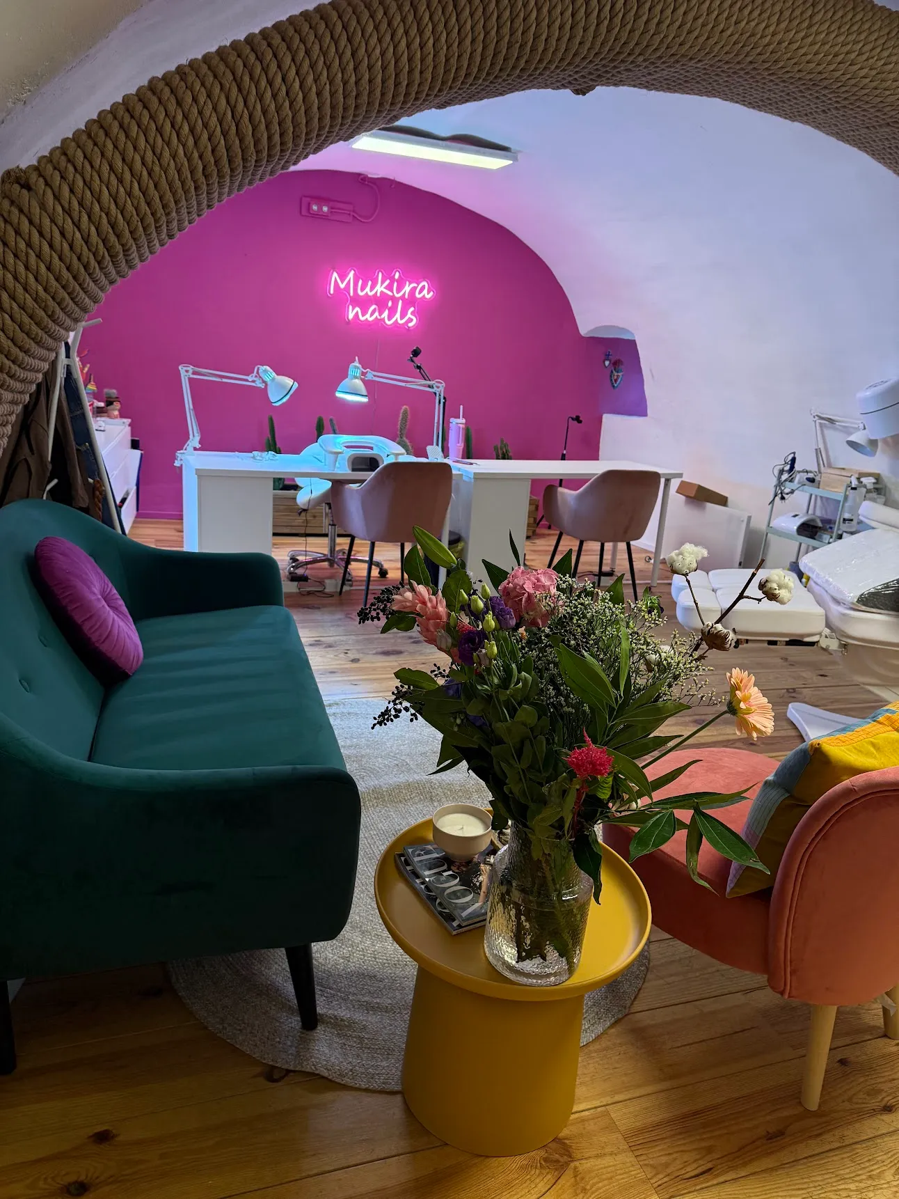 Inside the Mukira Nails studio with the pink wall and neon sign